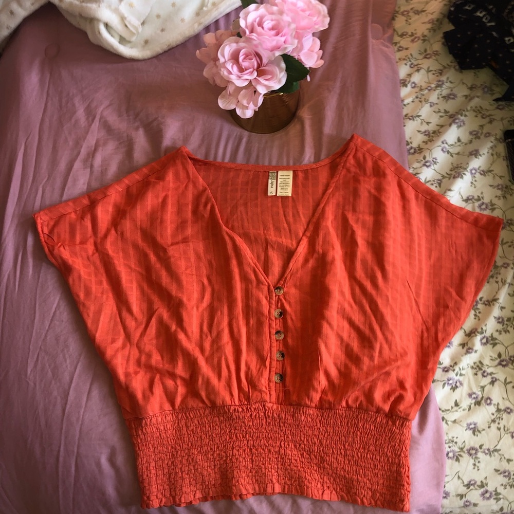 Orange top with some beige black buttons